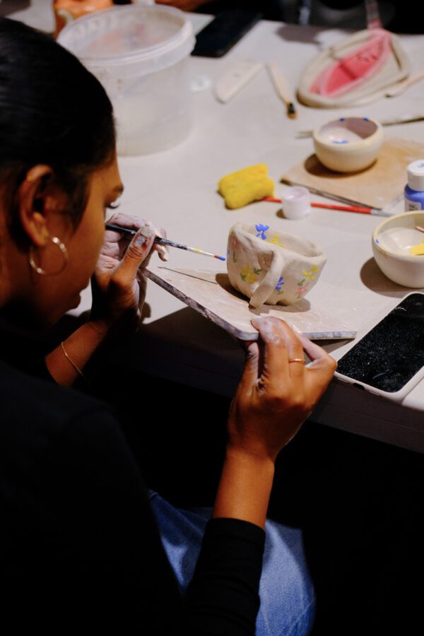 a woman painting a cup
