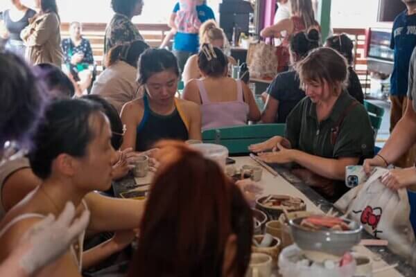 Large group of people performing a handbuilding classs